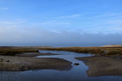 Scenic view of beach against blue sky