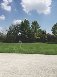 Scenic view of grassy field against sky