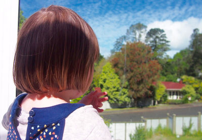 Close-up of boy standing against trees