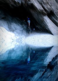 Reflection of person on rock in water