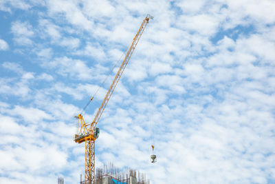 Low angle view of cranes against sky