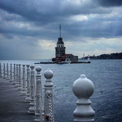 View of building in sea against cloudy sky