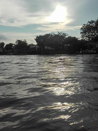 Scenic view of river against sky at sunset