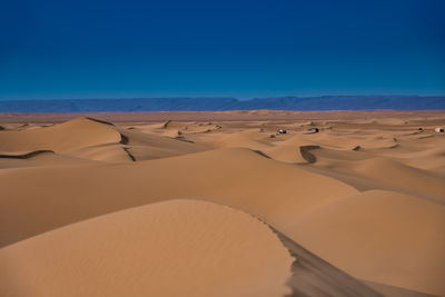 Scenic view of desert against clear blue sky