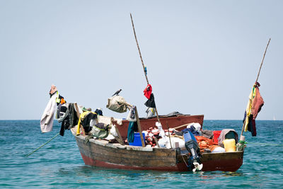 Fishing boats in sea against clear sky