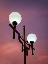 Low angle view of illuminated street light against sky at sunset