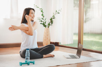 Young woman using mobile phone at home