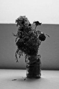 Close-up of flower vase on table against wall