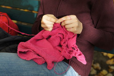 Midsection of person holding red toy