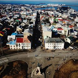 High angle view of town by sea against sky
