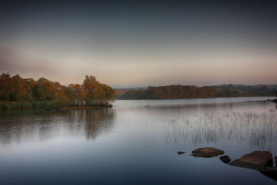 Scenic view of lake against sky at sunset