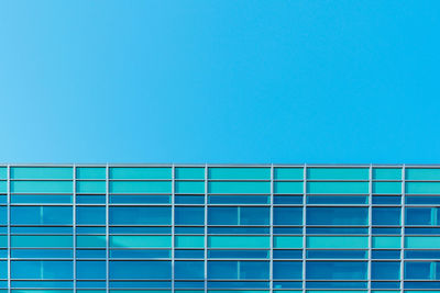 Low angle view of modern building against clear blue sky