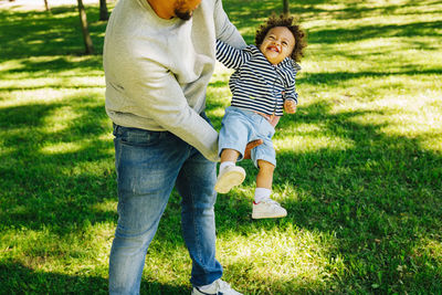 Rear view of father and son on grassland