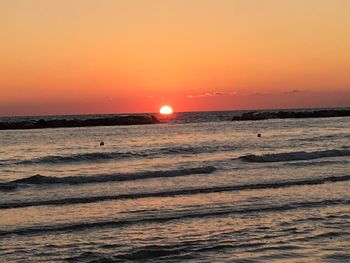 Scenic view of sea against orange sky