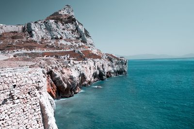 Rock formations in sea against sky