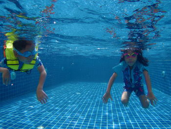 Siblings swimming in pool