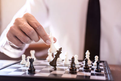 Midsection of man playing on chess board