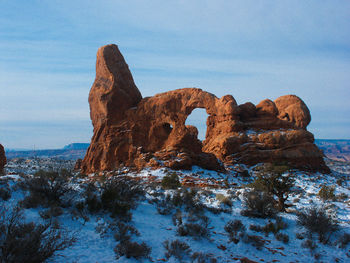 Rock formation at arches national park against sky during winter