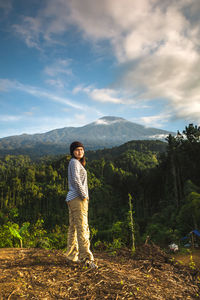 Full length of woman standing on mountain against sky