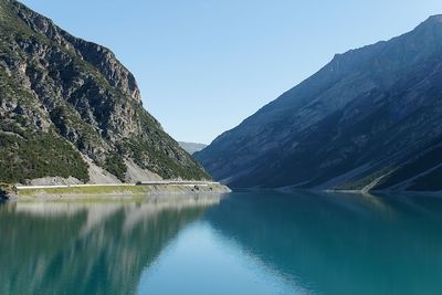 Scenic view of lake and mountains against clear blue sky