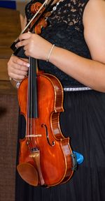 Midsection of woman playing guitar at music concert