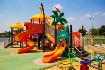 Empty swing in playground against sky