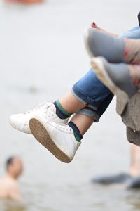 Girl with the shoes at the bank of the river