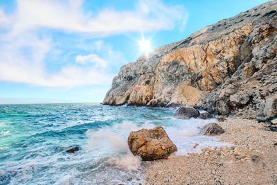 Scenic view of rocks on beach against sky