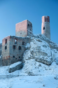 Low angle view of fort against clear blue sky