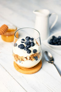 Healthy food concept. homemade granola with nuts and honey in a glass with yogurt and fresh berries 