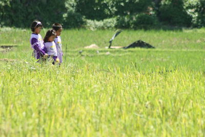 Siblings standing at rice paddy