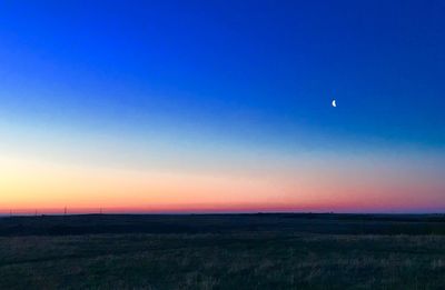 Scenic view of field against clear sky at sunset