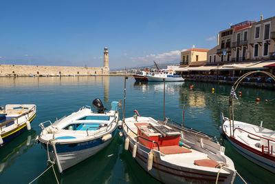 Boats moored at harbor by buildings in city