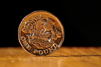 Close-up of coin on table against black background