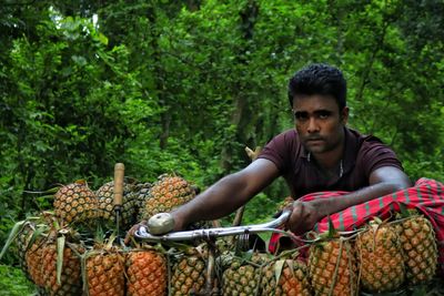 Portrait of man holding pineapple for sale