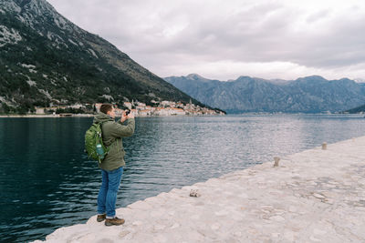 Rear view of woman standing at lake