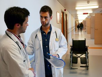 Doctors standing and discussing in hospital corridor