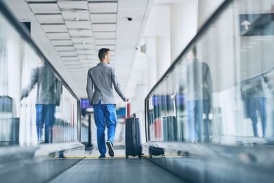 Rear view of man walking in airport building