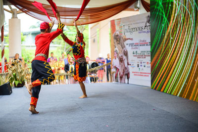 People holding multi colored umbrellas hanging in city