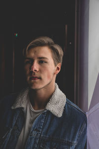 Portrait of young man looking away at home