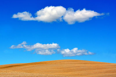 High section of countryside landscape against blue sky