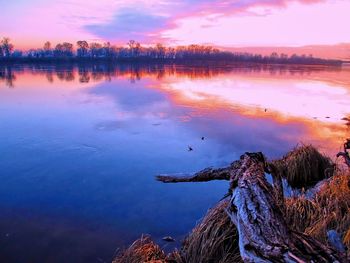 Scenic view of lake against sky at sunset