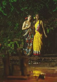 Portrait of friends standing against trees