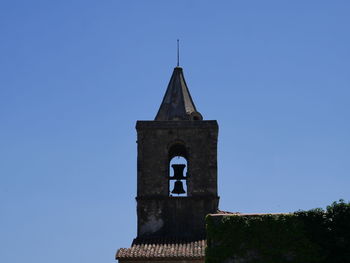 Low angle view of bell tower against clear blue sky