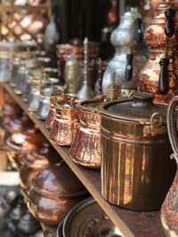 Close-up of old utensils arranged on shelf for sale in market