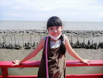 Portrait of girl on beach against sky