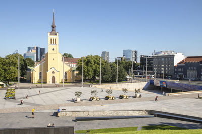 View of buildings in city against clear blue sky