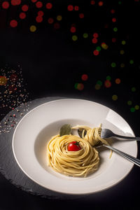 Food concept with spaghetti and cherry tomatoes on illuminated b