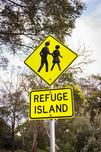 Close-up of road sign against trees