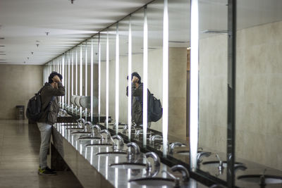 Side view of man standing in public restroom